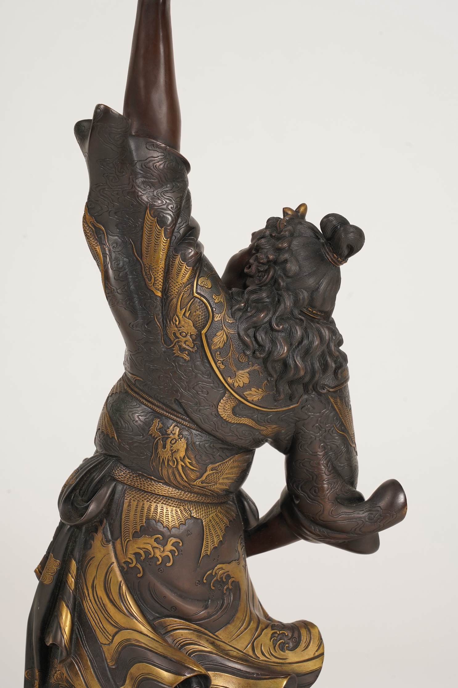 A large Japanese Miyao style parcel gilt bronze figure holding a koro aloft, 20th century